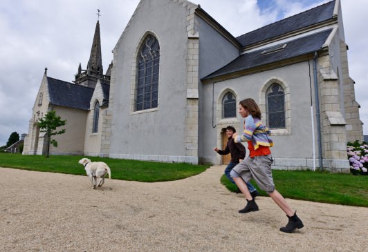 stockphoto, stockfoto, rennende kinderen met hond bij kerk in frans dorp, scrignac, playing kids with dog in french village